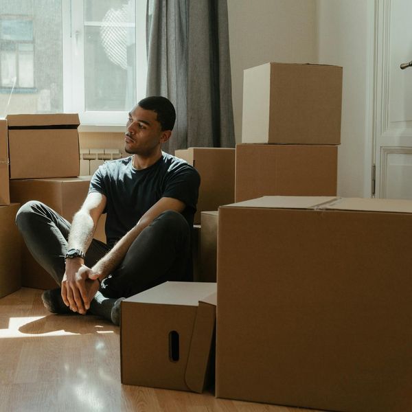 Person meditating peacefully in a lotus position in a minimalist room.